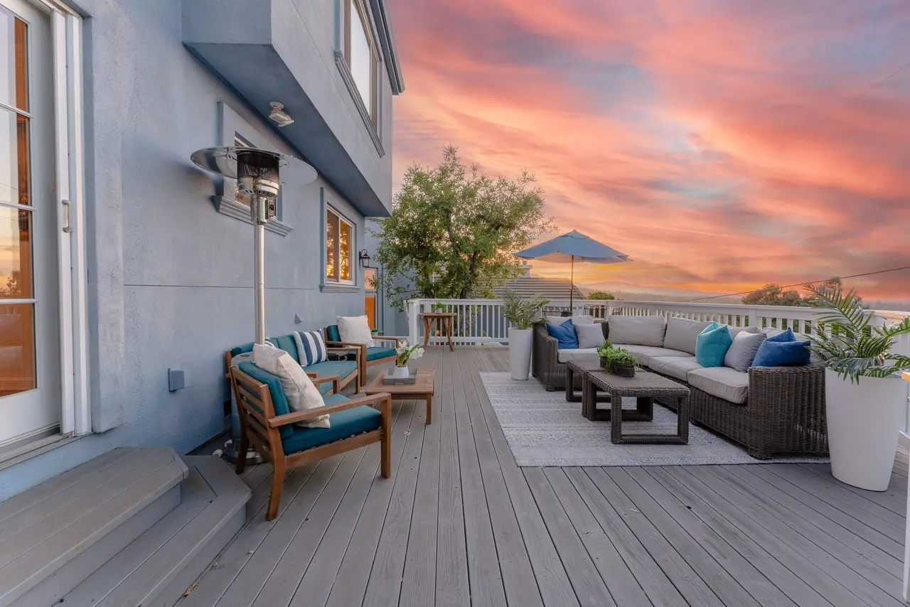 View deck at sunset with outdoor sofas and a patio heater