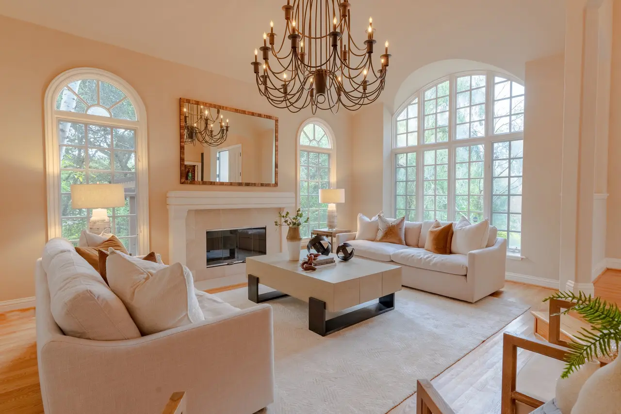 Great room with arched windows, a fireplace, and a chandelier