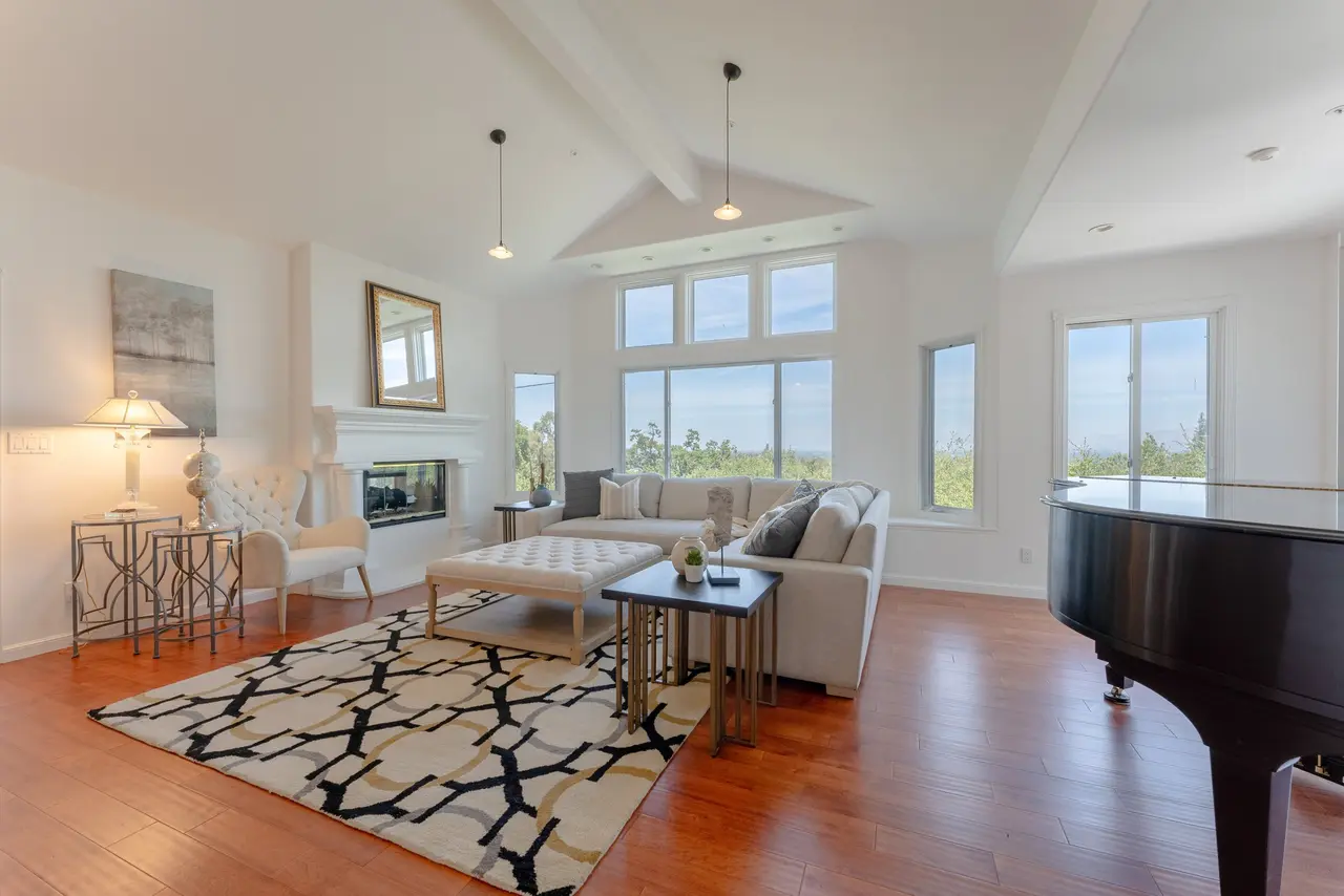 Family room with a vaulted ceiling, a fireplace, and treetop views