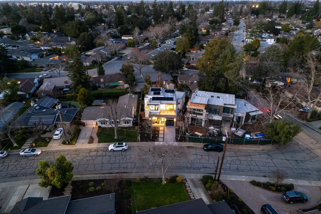 Aerial view of the home and the tree-lined neighborhood at dusk