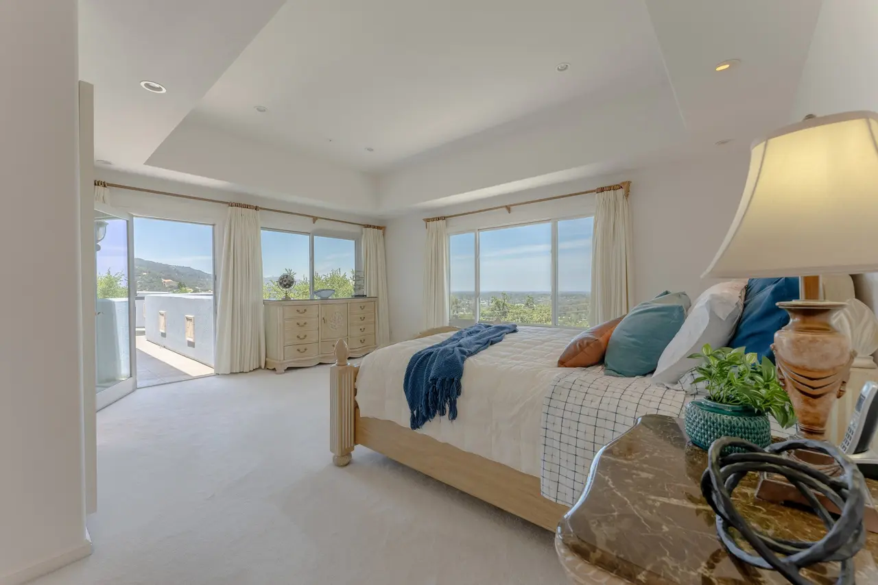 Primary bedroom with a tray ceiling and doors to a private deck